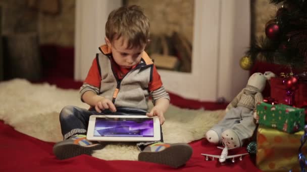 Menino com tablet PC perto da árvore de natal — Vídeo de Stock