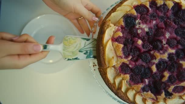 Frau legt ein Stück Kuchen auf einen Teller — Stockvideo