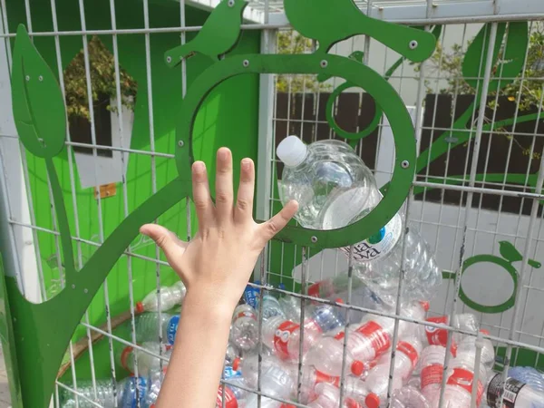 Ręka Dziecka Wyrzucającego Pustą Plastikową Butelkę Zbiornika Koncepcja Edukacji Ekologicznej — Zdjęcie stockowe