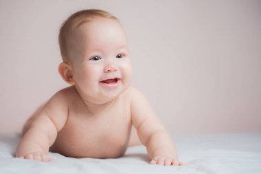 Beyaz güneşli yatak odasında bebek bezi takan yeni doğmuş bir çocuk. Yeni doğmuş çocuk yatakta dinleniyor. Güzel bir kız mutlu bir gülümseme, her amaçla harika bir tasarım sergiler. Mutlu bir aile. Komik kız..