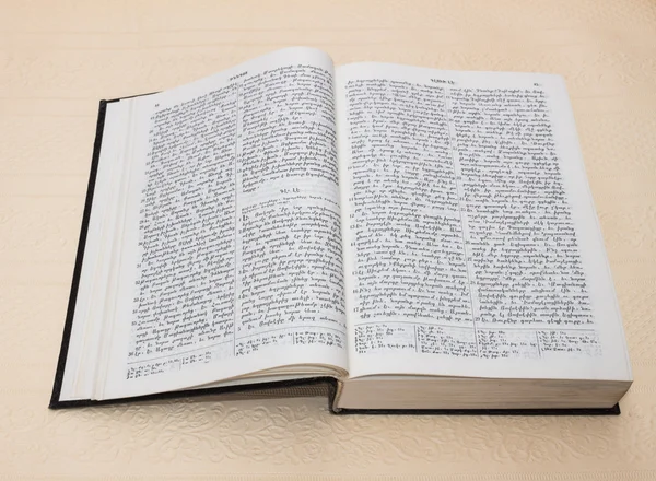 Библия - открытая книга с текстом на белой бумаге — стоковое фото