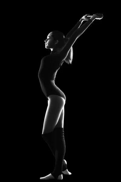 fitness, sport, people and healthcare concept - Young cute woman in gymnast suit show athletic skill on black background