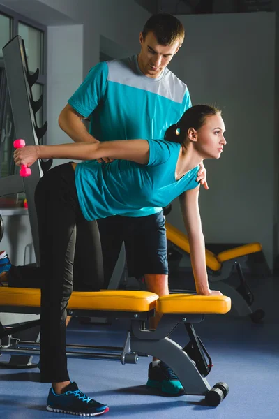 Фитнес спортивный молодой сексуальной женщины в тренажерном зале делать упражнения с гантелями . — стоковое фото