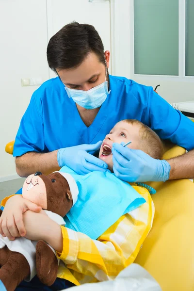 Il dentista tratta denti di paziente in clinica dentale — Foto Stock