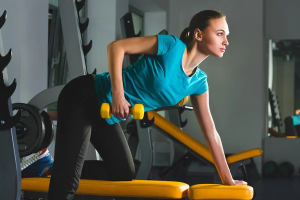 Sportowy młoda kobieta sexy fitness w siłowni, ćwiczenia z hantlami — Zdjęcie stockowe