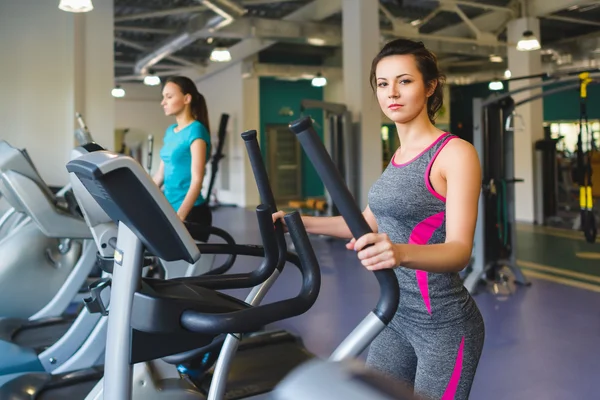 Çapraz bir eğitmen olarak spor salonunda egzersiz kadın — Stok fotoğraf