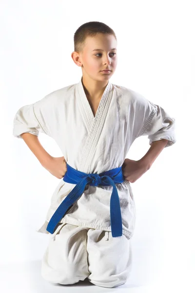 Ragazzo in kimono durante l'allenamento di karate esercizi su sfondo bianco — Foto Stock