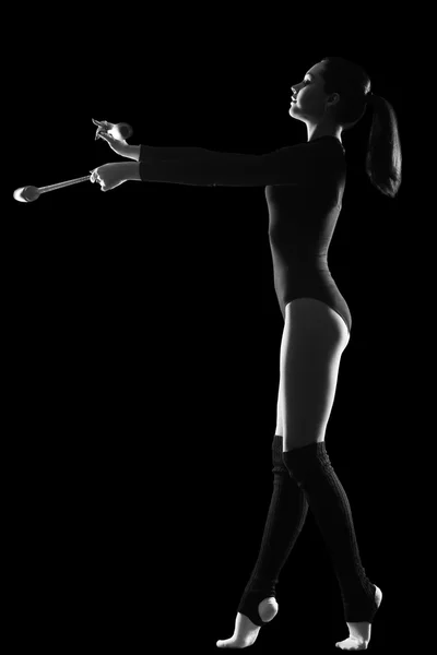 Fitness, sport, mensen en gezondheidszorg concept - jonge leuke vrouw in gymnast pak Toon atletische vaardigheid op zwarte achtergrond — Stockfoto