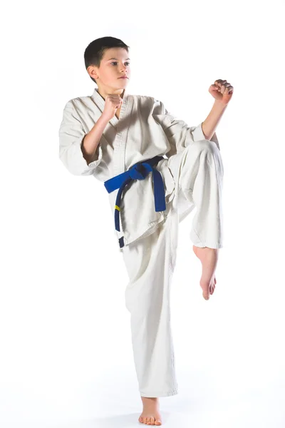 Karate ragazzo in kimono lotta su uno sfondo bianco — Foto Stock