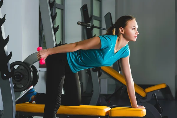 Фитнес спортивный молодой сексуальной женщины в тренажерном зале делать упражнения с гантелями — стоковое фото