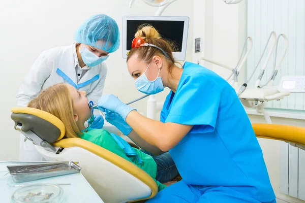 Dentista e enfermeira fazendo profissional dentes limpeza jovem paciente do sexo feminino no consultório odontológico — Fotografia de Stock