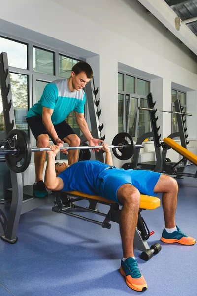 Jeune homme dans la salle de gym exercice poitrine sur le banc presse avec haltère — Photo