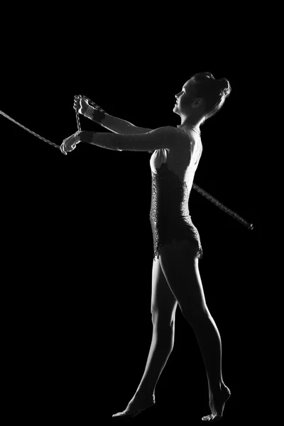 Fitness, deporte, personas y concepto de salud - Mujer linda joven en traje de gimnasta muestran habilidad atlética en el fondo negro — Foto de Stock