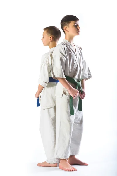 Jongens in kimono tijdens de training van karate oefeningen op witte achtergrond — Stockfoto