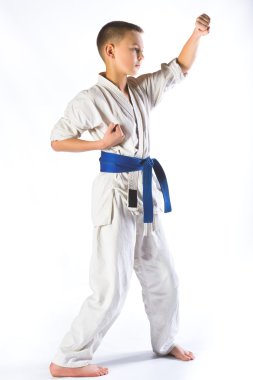 Karate çocuk beyaz bir arka plan üzerinde mücadele kimono içinde