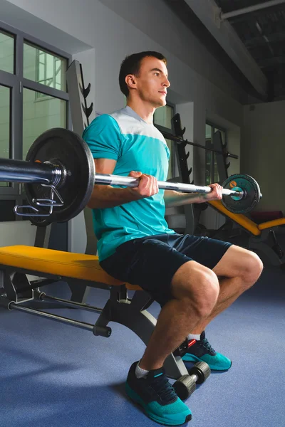 Atleta musculoso fisiculturista no ginásio treinamento com bar — Fotografia de Stock