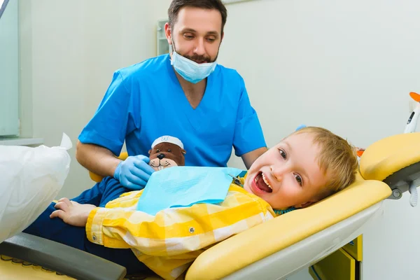 Il dentista tratta denti di paziente in clinica dentale — Foto Stock