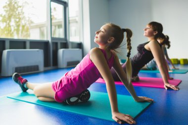 Kızlar ve eğitmen ya da fitness sınıfta jimnastik egzersizleri yapıyor anne