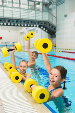 Mutlu ve gülümseyerek grup çocuk yüzme havuzunda egzersizleri yapıyor