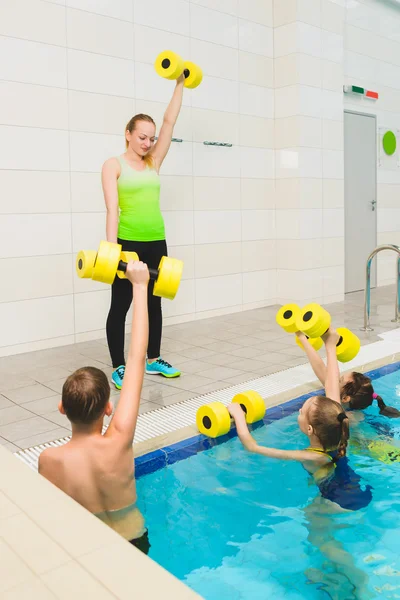 Instructor and group of children doing exercises in a swimming pool — Stock Photo, Image