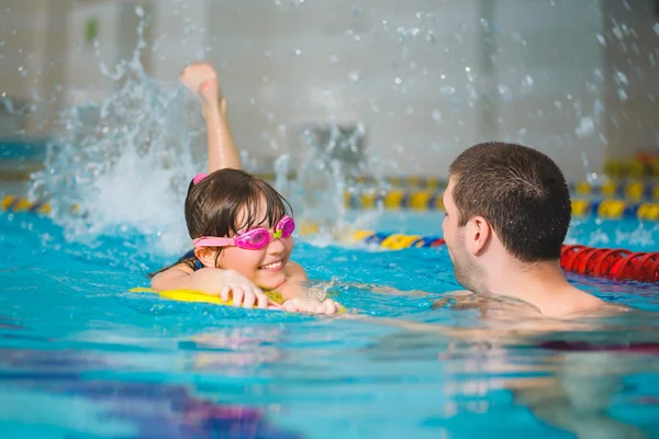 Instructor teaches the girl swimming in a pool — Stock Photo, Image