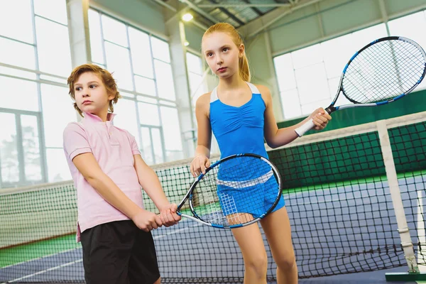Niños jugando tenis y posando en interiores —  Fotos de Stock