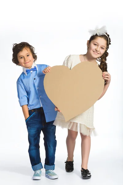 Ragazzo e ragazza con un cuore di cartone. Concetto amore — Foto Stock