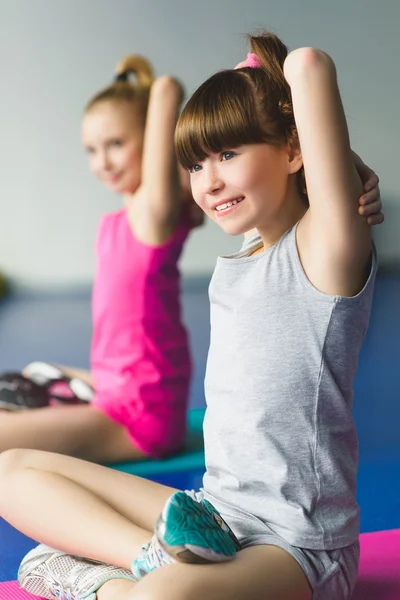 Dos chicas haciendo yoga estirándose en clase de fitness — Foto de Stock