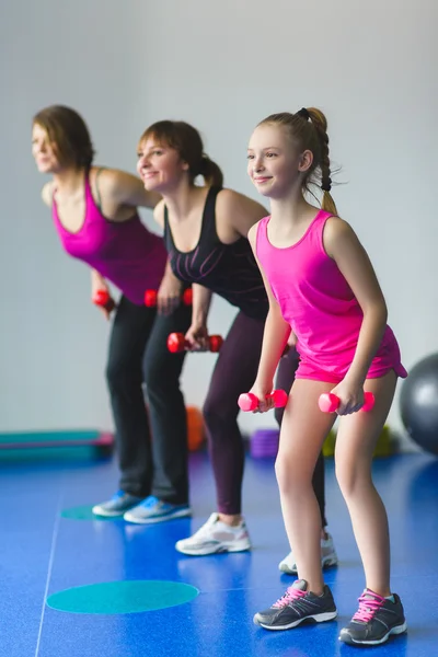 Dos mujeres jóvenes y una niña haciendo ejercicios de gimnasia — Foto de Stock