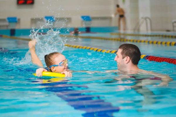 Instructor teaches the girl swimming in a pool — Stock Photo, Image