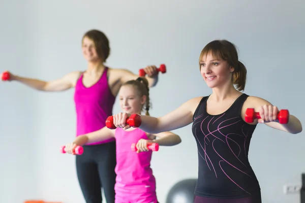 Dos mujeres jóvenes y una niña haciendo ejercicios de gimnasia — Foto de Stock