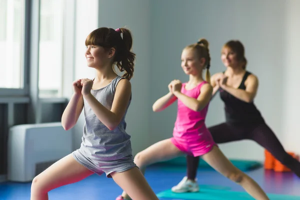 Chicas e Instructor o madre haciendo ejercicios gimnásticos en clase de fitness — Foto de Stock
