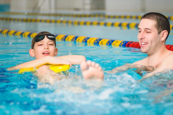 Lehrer bringt dem Jungen das Schwimmen im Pool bei — Stockfoto