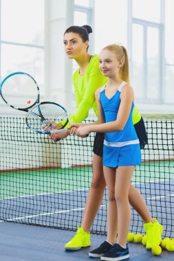 Öğretim görevlisi veya çocuk kapalı bir sahada tenis oynamayı öğreterek Koç