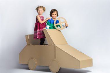 Mutlu kız ve erkek karton car yakınındaki gülümseyerek. tam uzunlukta portre