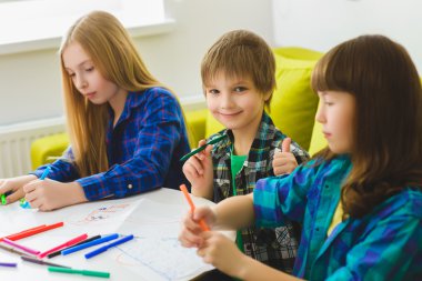mutlu çocuklar resim çiziyor. Odada kapalı. başparmak gösteren çocuk