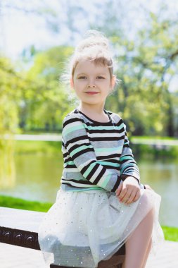 mutlu sarışın küçük kız parkta poz