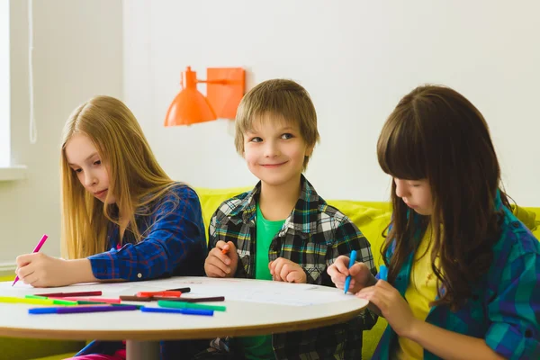 Gelukkig weinig meisjes en jongen afbeeldingen tekenen. Indoor op kamer — Stockfoto