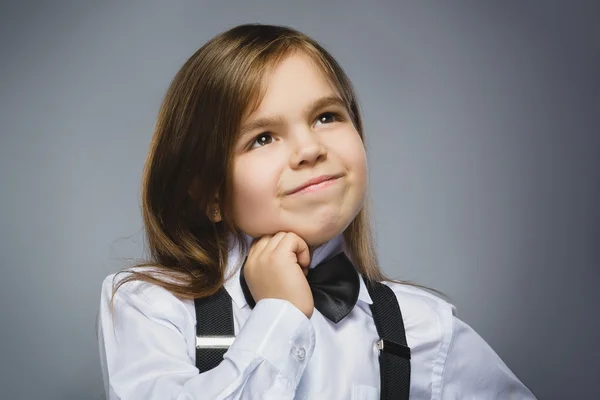 Nahaufnahme träumendes junges Mädchen, das vor grauem Hintergrund aufblickt — Stockfoto