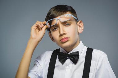 Closeup düşünceli genç çocukla gözlük gri arka plan karşı taraftan