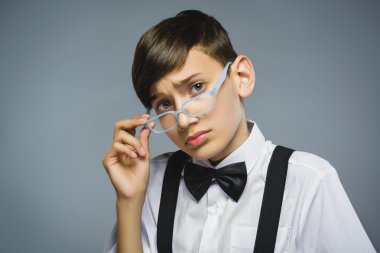 Closeup düşünceli genç çocukla gözlük gri arka plan karşı taraftan