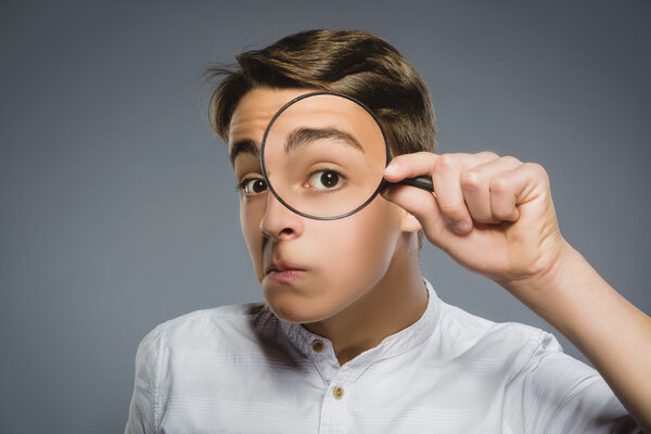 Boy See Through Magnifying Glass, Kid Eye Looking with Magnifier Lens over Gray