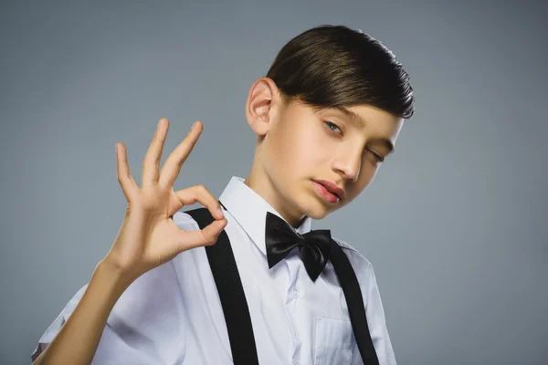 Chico feliz. Primer plano Retrato de adolescente guapo sonriendo y mostrar Ok sobre fondo gris — Foto de Stock