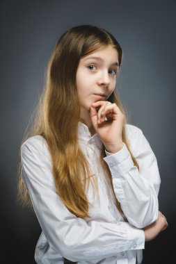 Closeup düşünceli genç kız Looking Up gri bir arka plana dayanır