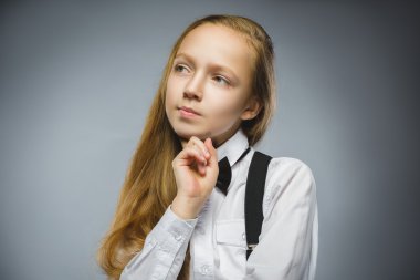 Closeup düşünceli genç kız Looking Up gri bir arka plana dayanır