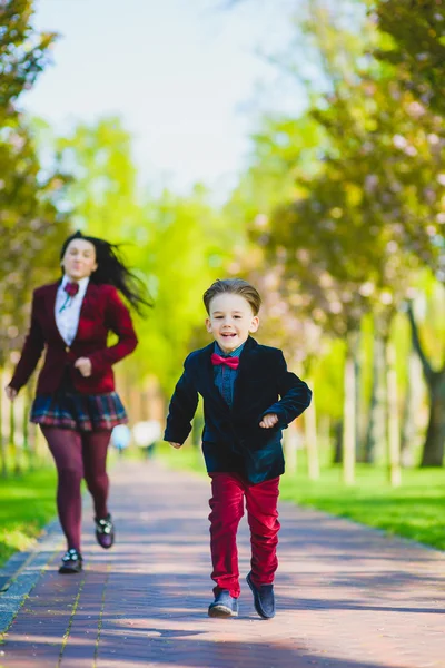 Elegante chico y mujer de moda o hijo con madre jugando al aire libre — Foto de Stock