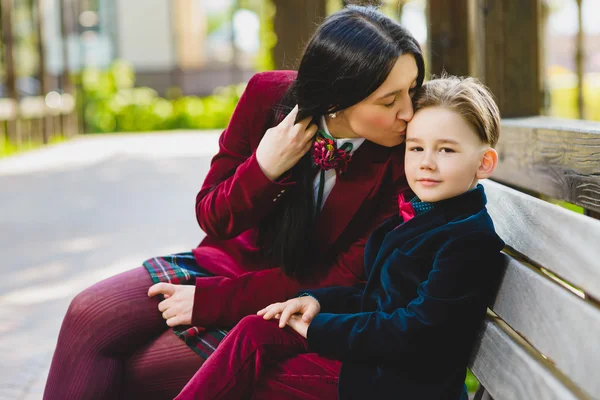 Madre alla moda baciare il suo elegante figlio all'aperto — Foto Stock