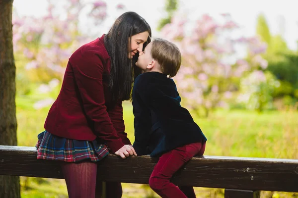 Madre alla moda baciare il suo elegante figlio all'aperto — Foto Stock