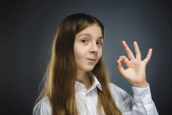 Glückliches Mädchen. Nahaufnahme Porträt eines hübschen Teenagers in lässigem Hemd lächelnd zeigen ok isoliert auf grauem Hintergrund — Stockfoto