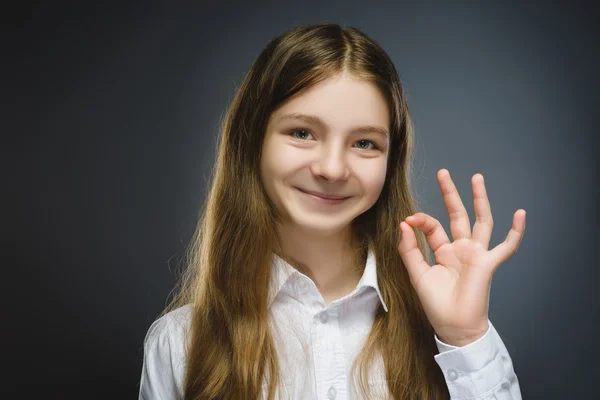 Glückliches Mädchen. Nahaufnahme Porträt eines hübschen Teenagers in lässigem Hemd lächelnd zeigen ok isoliert auf grauem Hintergrund — Stockfoto